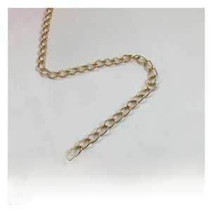 Dettaglio di una tracolla a catena in metallo dorato per borsa a secchiello alla moda