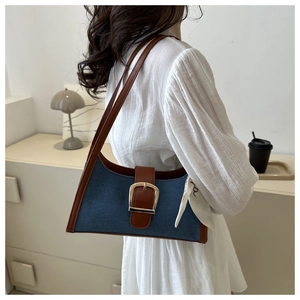 Sac bandoulière en denim avec garniture en cuir et foulard, porté par un mannequin