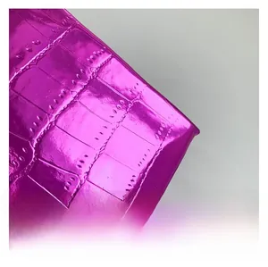 Dettaglio della trama a coccodrillo rosa metallizzato sulla borsa a secchiello