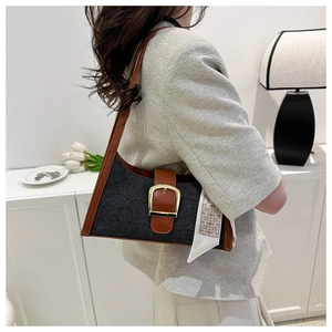 Détail d'un sac d'épaule en denim et cuir marron avec boucle dorée et un foulard en soie chic