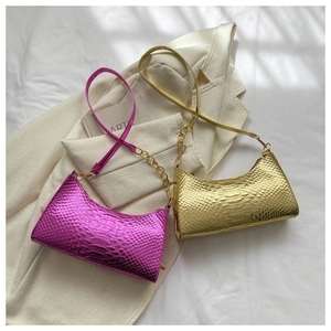 Detail of snake pattern texture on metallic purple and gold shoulder bags for women