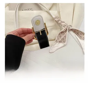 Detail shot of the golden magnetic buckle and V-shaped quilted texture on white leather bag