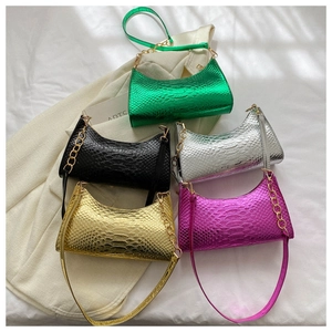 Detail of stylish crocodile pattern shoulder bags in gold, silver, black, green and purple