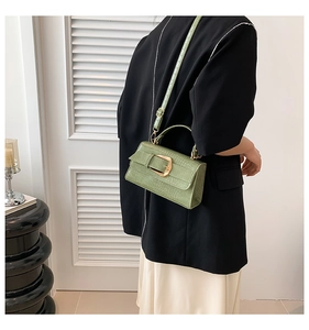 Détail du sac à main vert clair motif crocodile avec fermoir en métal doré chic