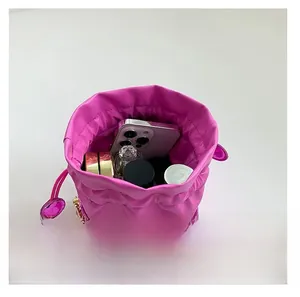 Capacità interna della borsa a secchiello fucsia con coulisse, catena dorata e trucchi