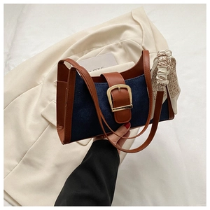 Vue détaillée du sac en denim avec bordure en cuir brun et foulard en soie décoratif