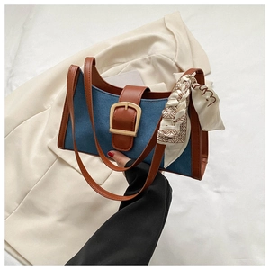 Détail du sac à bandoulière en denim et cuir avec boucle dorée et foulard en soie
