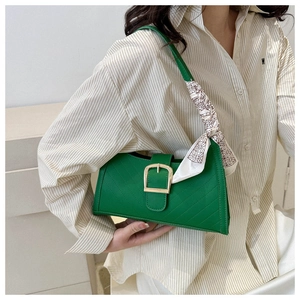 Detail of green quilted underarm bag with golden square buckle and floral silk scarf