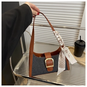 Détail du sac sous le bras en denim patchwork avec boucle dorée et décor de foulard en soie