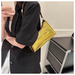 Close-up of the shiny gold faux leather bag with elegant crocodile pattern texture