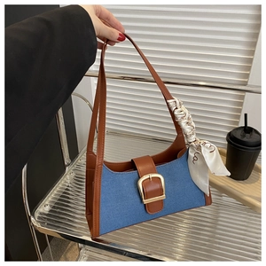 Détail du sac d'épaule rétro en jean avec finitions en cuir et foulard décoratif en soie