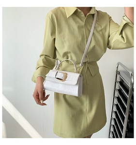 Détail du sac à main blanc à motif crocodile avec boucle en métal doré et poignée