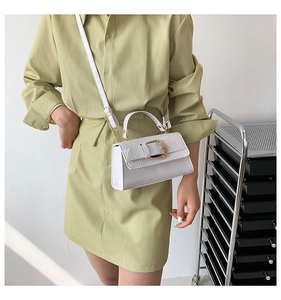 Détail du sac à bandoulière blanc à motif crocodile avec boucle D dorée et sangle