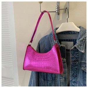 Detail of rose red metallic patent leather shoulder bag with crocodile embossing
