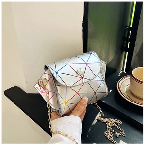 Macro shot of silver mini crossbody bag featuring holographic geometric triangle patterns