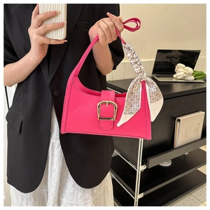 Detail of fuchsia quilted handbag with gold buckle and decorative geometric silk scarf