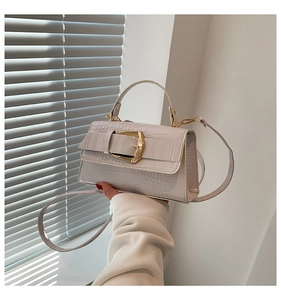 Détail de la texture imitation crocodile blanc cassé et de la boucle dorée de ce sac à main