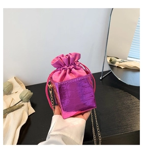 Dettaglio borsa a secchiello fucsia metallizzata a coccodrillo con catena dorata