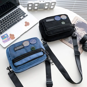Detailed view of canvas crossbody bags with mesh front pockets in black and blue styles