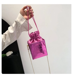 Dettaglio borsa a scatola fucsia coccodrillo con sacchetto a coulisse e catena d'oro
