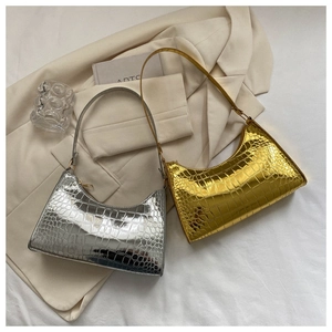 Detailed close-up of glossy crocodile texture on gold and silver metallic hobo bags