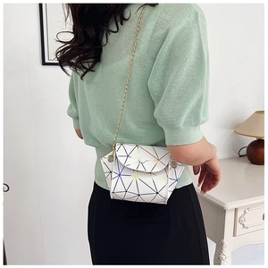 Close-up of geometric white shoulder bag with holographic prism patterns and gold chain