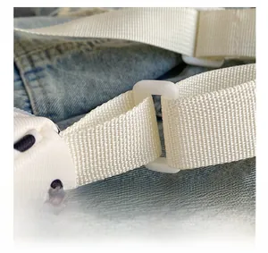 Macrodetail van een witte nylon schouderriem met gesp op een handtas met witte stippen