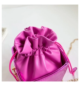 Dettaglio della borsa a secchiello magenta con trama a rilievo e chiusura a coulisse