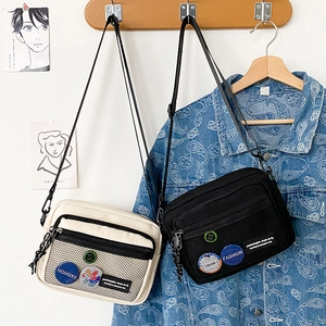 Detail of minimalist canvas crossbody bags in black and white with nylon mesh pockets