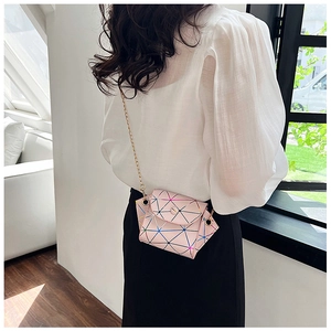 Macro view of pink geometric mini crossbody bag with golden chain strap on a model