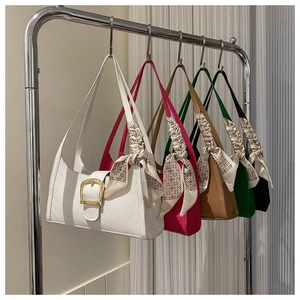 Detailed row of quilted shoulder bags in five colors with metal buckles and silk scarves