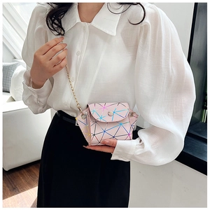 Model wearing a mini pink holographic geometric chain crossbody bag in a home setting