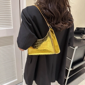Golden crocodile embossed patent leather baguette bag styled with black blazer suit