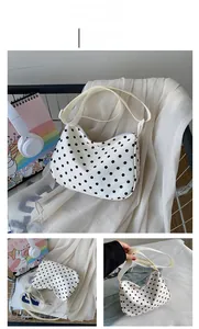 Detailweergave van de gebroken witte hobo-tas met zwarte stippen en verstelbare riem