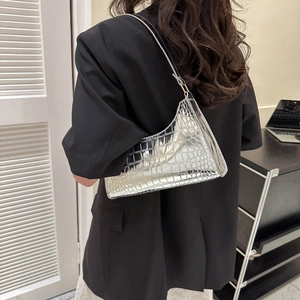 Silver glossy crocodile texture baguette bag with metallic finish for women on model