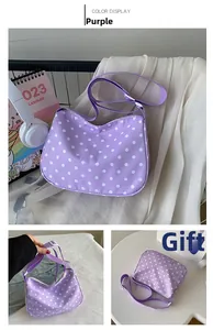 Detailweergaven van paarse polkadot nylon schoudertas met verstelbare riem en rits