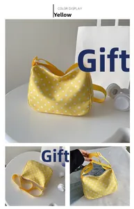 Detail van gele nylon crossbodytas met stippen, ritssluiting en verstelbare riem