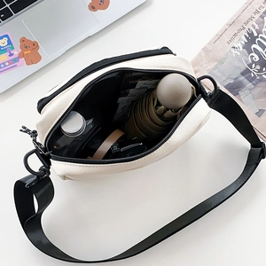 Spacious off-white canvas crossbody bag showing daily essentials storage capacity