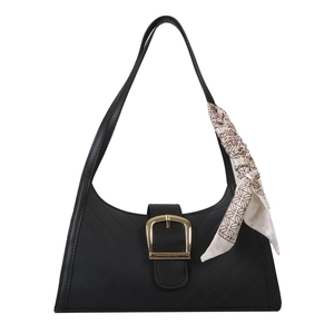 Minimalist black quilted shoulder bag with golden horseshoe buckle and decorative silk scarf