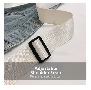 Detail view of the adjustable white nylon strap and light blue denim fabric texture