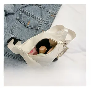 Detail view of the spacious inner compartment of the ivory nylon crescent bag