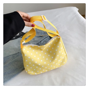 Detail van gele nylon crossbodytas met polkadots, verstelbare riem en witte gesp