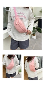 Detail of pink nylon waist bag showing dual zippers and adjustable buckle strap