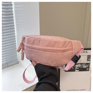 Detail of pink nylon waist bag showing zipper main pocket and woven rope pullers
