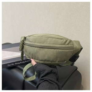 Detail view of army green nylon waist bag featuring woven zipper pull and plastic buckle strap