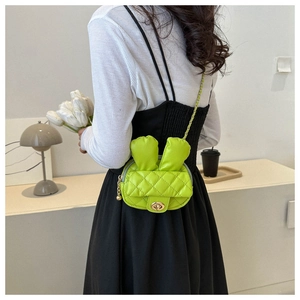 Bright green mini crossbody bag with rabbit ears and chain strap shown on model back