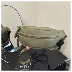 Detail of army green nylon belt bag with woven zipper pulls and plastic buckle