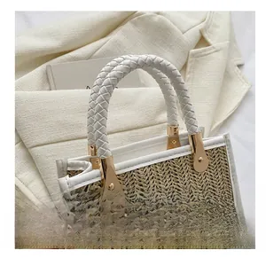 Détail d'un sac en paille avec poignées tressées blanches et broderie fashion