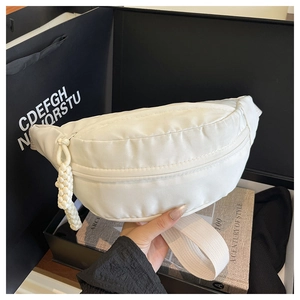 Detailed macro view of a white nylon crescent fanny pack with woven zipper puller