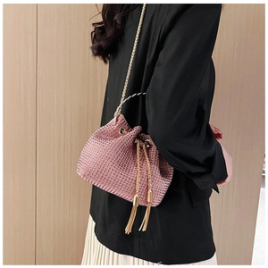 Close-up of pink rhinestone bucket bag with golden chain and tassel drawstring closure